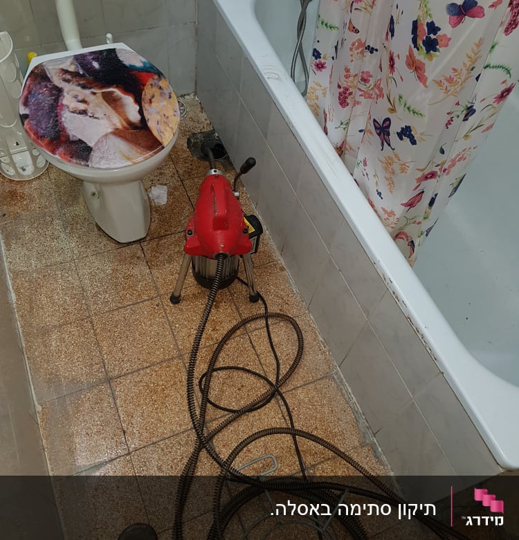 מכונת ניקוי צינורות עם כבל ארוך בחדר אמבטיה